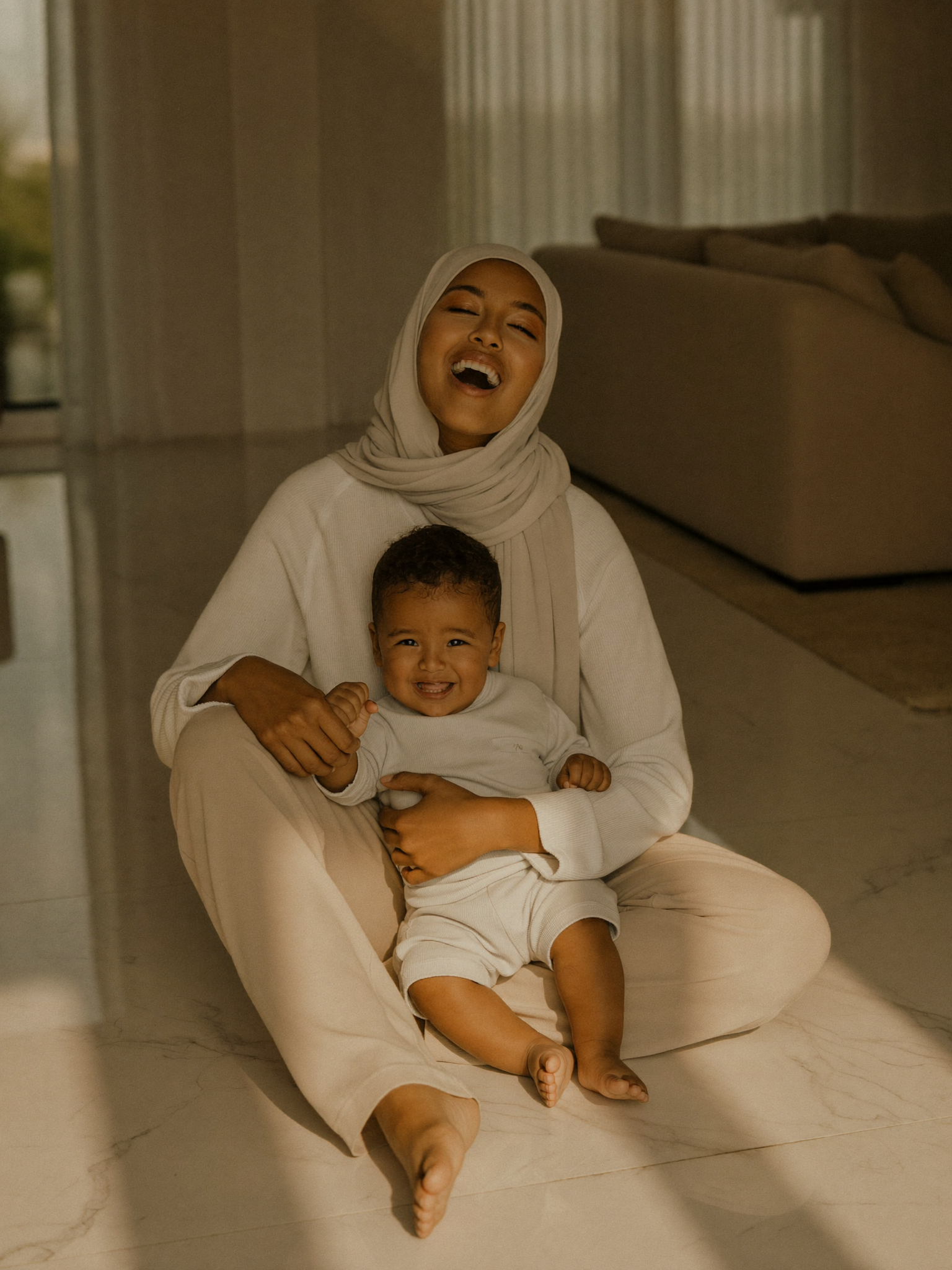 A mother laughing with her son on a spotless villa floor